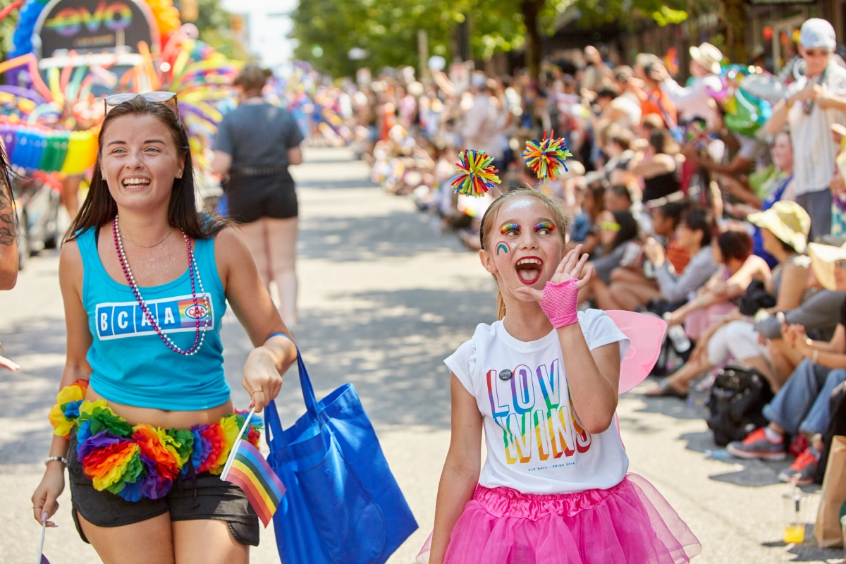 Corporate event photograph candid of staff walking Vancouver Pride Parade and crowd watching