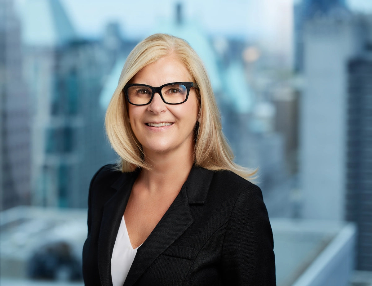 corporate headshot of a woman with glasses and a window view background taken in a Vancouver office